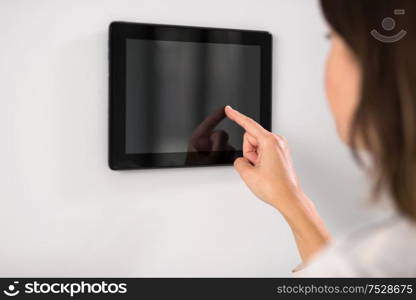 automation, internet of things and technology concept - woman using tablet pc computer at smart home. woman using tablet computer at smart home