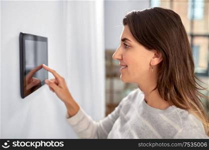 automation, internet of things and technology concept - woman using tablet pc computer at smart home. woman using tablet computer at smart home