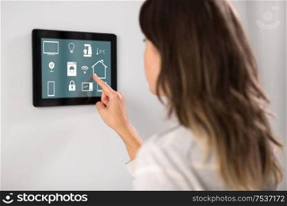 automation, internet of things and technology concept - woman using tablet pc computer at smart home. woman using tablet computer at smart home
