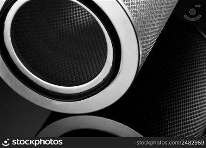 automotive filter cylindrical shape on a black background with reflection. automobile filter on a black background