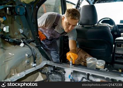 Automotive worker engaged in car body work. Repair and paint vehicle after accident. Automotive worker engaged in car body work