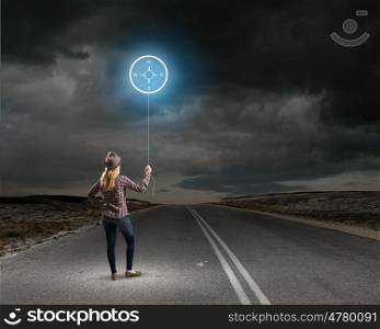 Autostop traveling. Rear view of woman in casual holding balloon in hand