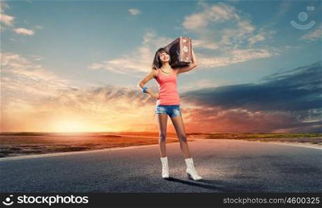 Autostop traveling. Young pretty woman tourist with suitcase with suitcase on shoulder