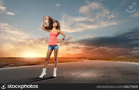 Autostop traveling. Young pretty woman tourist with suitcase with suitcase on shoulder