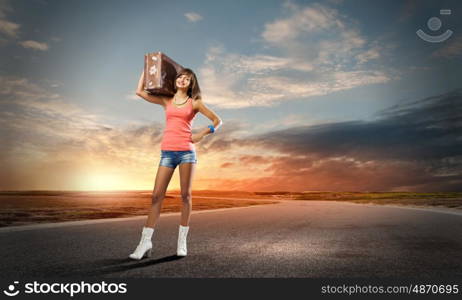 Autostop traveling. Young pretty woman tourist with suitcase with suitcase on shoulder