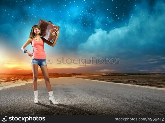 Autostop traveling. Young pretty woman tourist with suitcase with suitcase on shoulder