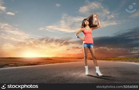 Autostop traveling. Young pretty woman tourist with suitcase with suitcase on shoulder