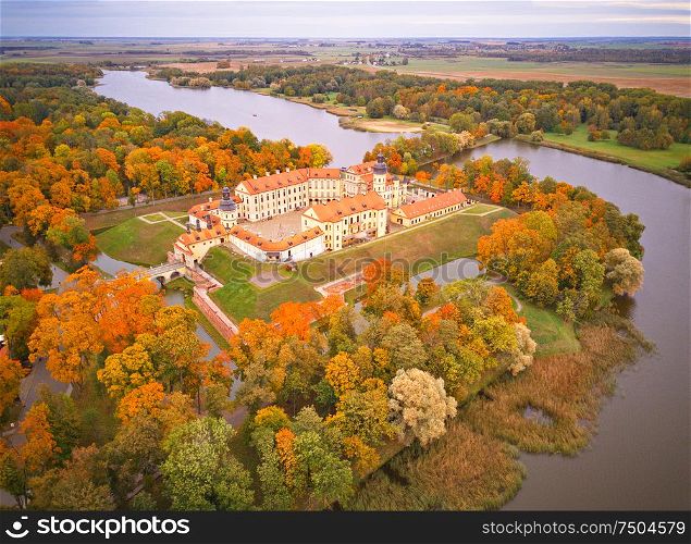 Autumn aerial view of Medieval castle in Nesvizh. Colorful maple park in Niasvizh ancient town. Minsk Region, Belarus