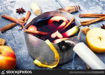autumn alcohol drink. pot with red mulled wine with apple and spices