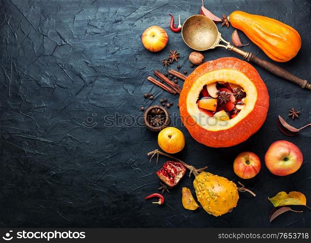 Autumn alcoholic drink mulled wine in pumpkin.. Traditional autumn mulled wine