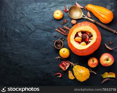 Autumn alcoholic drink mulled wine in pumpkin.. Traditional autumn mulled wine