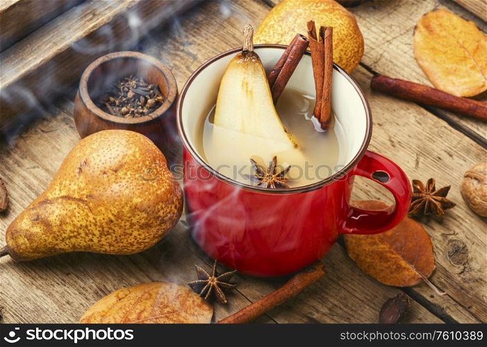 Autumn alcoholic drink.Warm pear mulled wine.Pear wine with spices on old vintage wooden table. Hot pear wine.