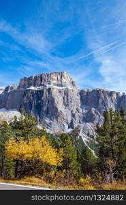 Autumn alpine Dolomites mountain scene, Sudtirol, Italy. Peaceful view near Sella Pass. Picturesque traveling, seasonal, nature and countryside beauty concept scene.