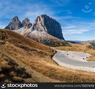 Autumn alpine Dolomites mountain scene, Sudtirol, Italy. Peaceful view near Sella Pass. Picturesque traveling, seasonal, nature and countryside beauty concept. People, cars and signs unrecognizable.