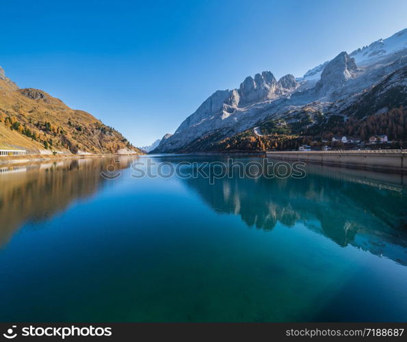 Autumn alpine Fedaia mountain Lake and Pass, Trentino, Dolomites Alps, Italy. Picturesque traveling, seasonal and nature beauty concept scene.