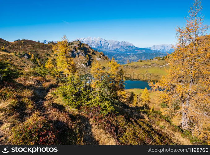 Autumn alpine Grosser Paarsee or Paarseen lake, Dorfgastein, Land Salzburg, Austria. Alps Hochkonig rocky mountain group view in far. Picturesque hiking, seasonal, and nature beauty concept scene.