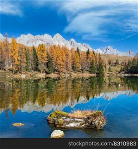 Autumn alpine mountain lake near San Pellegrino Pass, Trentino, Dolomites Alps, Italy. Picturesque traveling, seasonal and nature beauty concept scene.