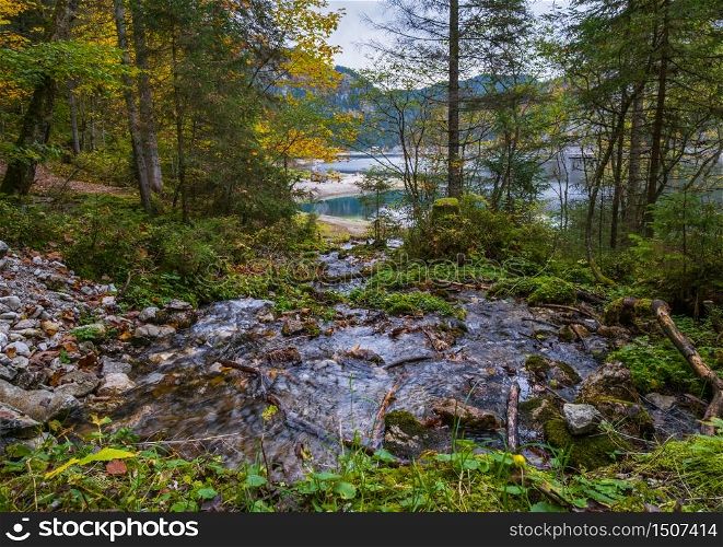 Autumn alpine stream view. Peaceful mountain lake with clear transparent water and reflections. Gosauseen or Vorderer Gosausee lake, Upper Austria.