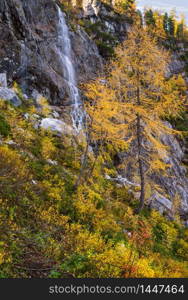 Autumn alpine waterfall view from mountain hiking path to Tappenkarsee, Kleinarl, Land Salzburg, Austria. Picturesque hiking, seasonal, and nature beauty concept scene.