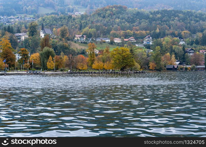 Autumn Alps mountain lake Mondsee misty view, Salzkammergut, Upper Austria. People unrecognizable.