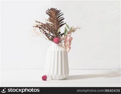 autumn and winter seasonal ikebana composition in white vase. dry flowers and leaves as home decor. cozy house decoration design details. autumn and winter seasonal ikebana composition in white vase. dry flowers and leaves as home decor. cozy house decoration design details.