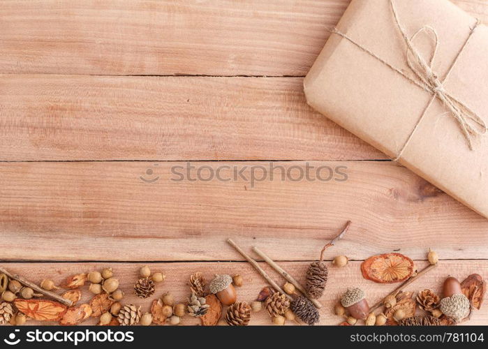 autumn background. cones,acorns and pieces of wood with a Packed parcel on a wooden background. the view from the top.