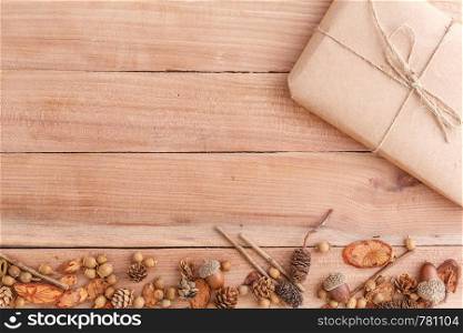 autumn background. cones,acorns and pieces of wood with a Packed parcel on a wooden background. the view from the top.