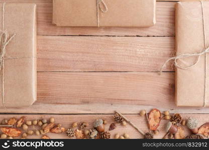 autumn background. cones,acorns and pieces of wood with a Packed parcel on a wooden background. the view from the top.