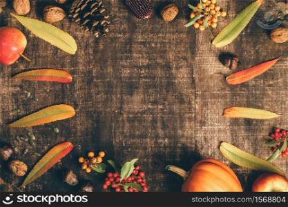 Autumn background - fallen leaves and healthy food on old wooden table. Thanksgiving day concept. Autumn background - fallen leaves and healthy food on old wooden table.