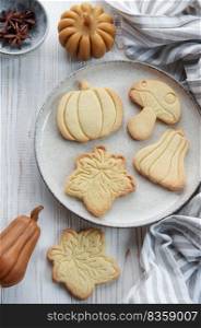 Autumn baking. Cookies in the form of pumpkin and leaves on the table. Cozy autumn concept.