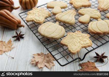 Autumn baking. Cookies in the form of pumpkin and leaves on the table. Cozy autumn concept.
