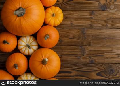 Autumn border of pumpkins on wood background with copy space. Border of pumpkins on wood background