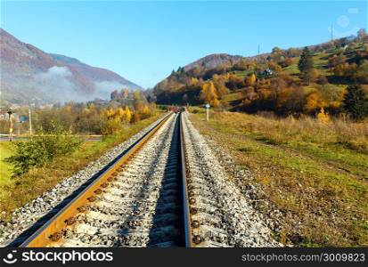 Autumn Carpathian Mountains misty landscape with railroad bridge and village outskirts (Rakhiv district, Transcarpathia, Ukraine).