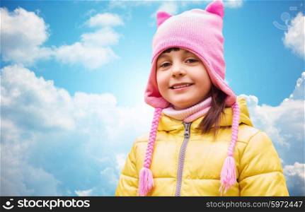 autumn, childhood, happiness and people concept - happy beautiful little girl portrait outdoors over blue sky and clouds background
