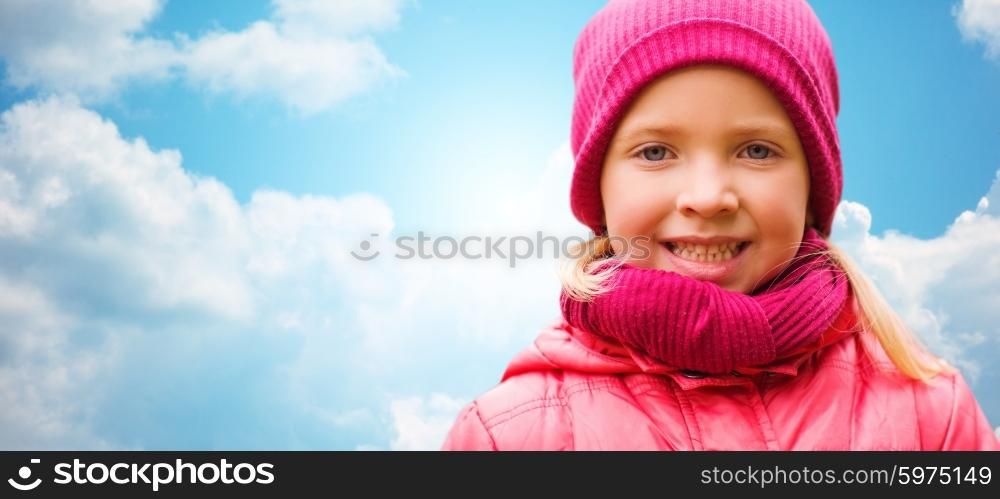 autumn, childhood, happiness and people concept - happy beautiful little girl portrait outdoors over blue sky background