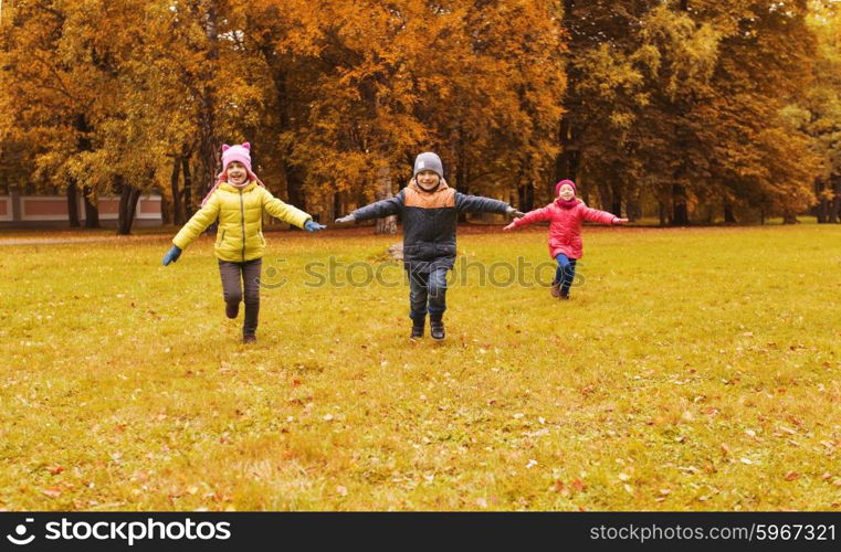 autumn, childhood, leisure and people concept - group of happy little children running and playing planes outdoors