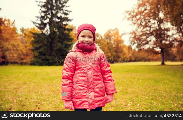 autumn, childhood, nature and people concept - happy little girl in park