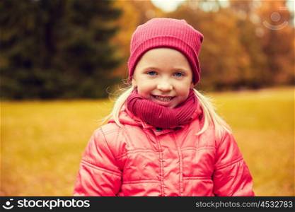 autumn, childhood, nature and people concept - happy little girl in park