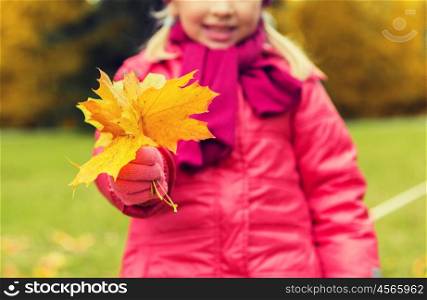 autumn, childhood, season and people concept - close up of happy little girl holding maple leaves bunch outdoors