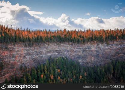 Autumn colors forest along mountain ledge