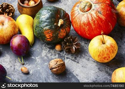 Autumn composing with pumpkin, fruit and fall leaves. Autumn fruit still life