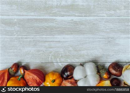 Autumn composition. Border of chestnuts, pine cones, physalis, acorn on wooden background. Flat lay, copy space. Autumn composition. Chestnuts, pine cones, physalis, acorn on wooden background. Flat lay