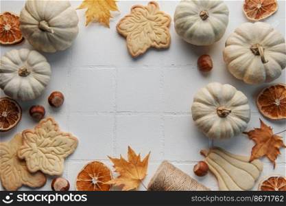 Autumn composition. Frame with pumpkins, dried leaves, cookies and nuts.  Autumn, fall, halloween, thanksgiving concept. Flat lay, top view, copy space