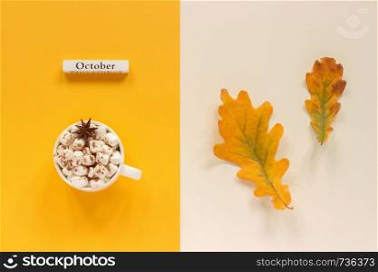 Autumn composition. Wooden calendar month October, cup of cocoa with marshmallows and autumn leaves on orange beige background. Top view Flat lay Copy space Concept Hello October.. Autumn composition. Wooden calendar month October, cup of cocoa with marshmallows and autumn leaves on orange beige background. Top view Flat lay Copy space Concept Hello October