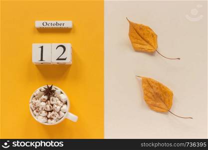 Autumn composition. Wooden calendar October 12 , cup of cocoa with marshmallows and yellow autumn leaves on yellow beige background. Top view Flat lay Mockup Concept Hello September.. Autumn composition. Wooden calendar October 12, cup of cocoa with marshmallows and yellow autumn leaves on yellow beige background. Top view Flat lay Mockup Concept Hello September