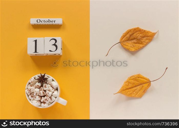 Autumn composition. Wooden calendar October 13, cup of cocoa with marshmallows and yellow autumn leaves on yellow beige background. Top view Flat lay Mockup Concept Hello September.. Autumn composition. Wooden calendar October 13, cup of cocoa with marshmallows and yellow autumn leaves on yellow beige background. Top view Flat lay Mockup Concept Hello September
