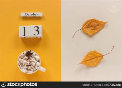 Autumn composition. Wooden calendar October 13, cup of cocoa with marshmallows and yellow autumn leaves on yellow beige background. Top view Flat lay Mockup Concept Hello September.. Autumn composition. Wooden calendar October 13, cup of cocoa with marshmallows and yellow autumn leaves on yellow beige background. Top view Flat lay Mockup Concept Hello September