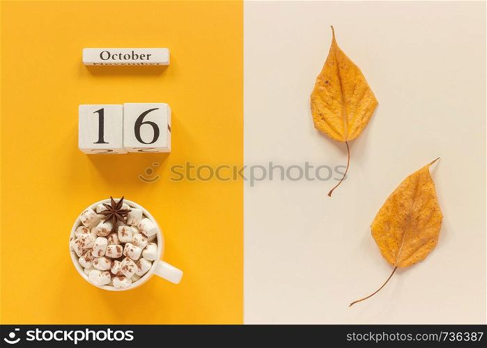 Autumn composition. Wooden calendar October 16, cup of cocoa with marshmallows and yellow autumn leaves on yellow beige background. Top view Flat lay Mockup Concept Hello September.. Autumn composition. Wooden calendar October 16, cup of cocoa with marshmallows and yellow autumn leaves on yellow beige background. Top view Flat lay Mockup Concept Hello September