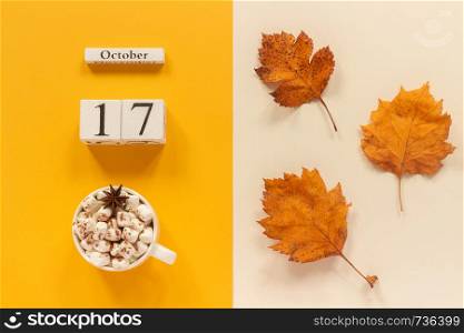 Autumn composition. Wooden calendar October 17, cup of cocoa with marshmallows and yellow autumn leaves on yellow beige background. Top view Flat lay Mockup Concept Hello September.. Autumn composition. Wooden calendar October 17, cup of cocoa with marshmallows and yellow autumn leaves on yellow beige background. Top view Flat lay Mockup Concept Hello September