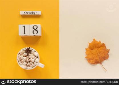 Autumn composition. Wooden calendar October 18, cup of cocoa with marshmallows and yellow autumn leaves on yellow beige background. Top view Flat lay Mockup Concept Hello September.. Autumn composition. Wooden calendar October 18, cup of cocoa with marshmallows and yellow autumn leaves on yellow beige background. Top view Flat lay Mockup Concept Hello September